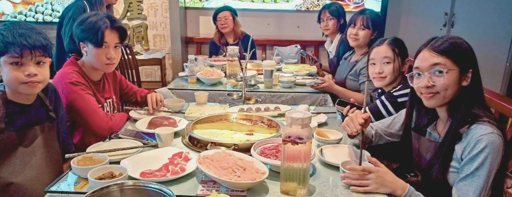 นักเรียนนั่งกินหม้อไฟฉงชิ่งพร้อมกันทั้งกลุ่ม